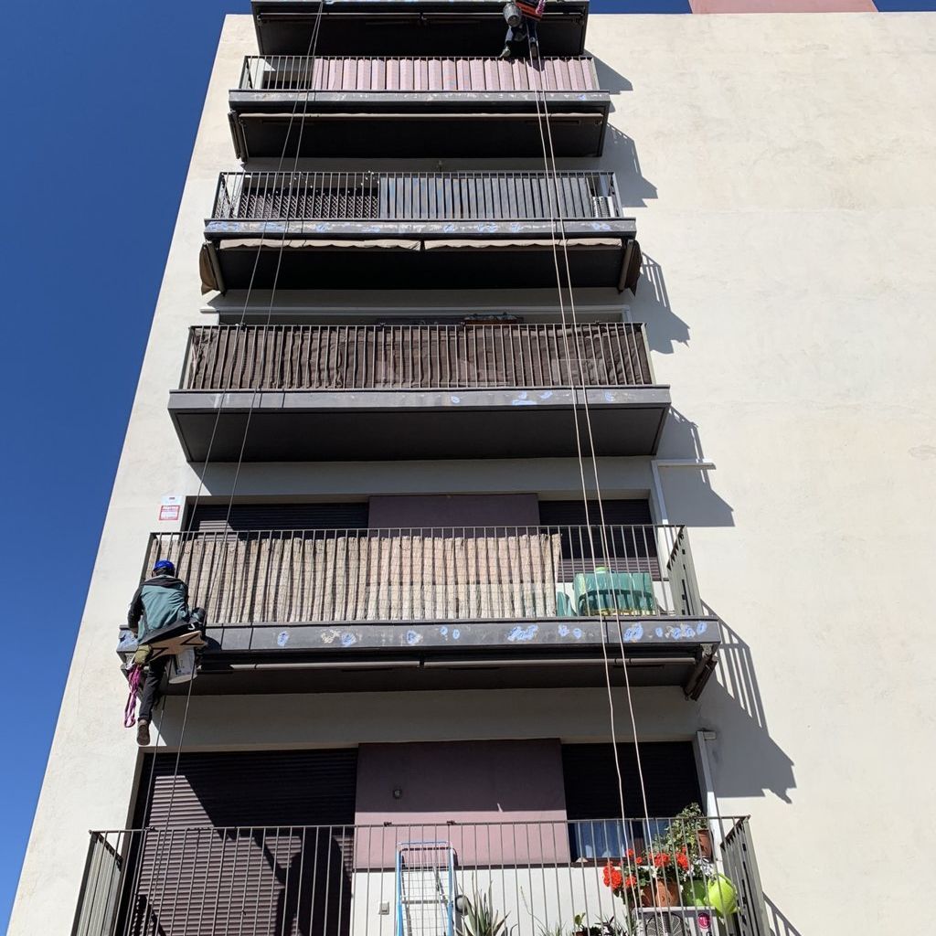 Hermes Vertical vista de edificio con cuerdas con obreros subidos